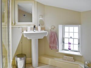 a bathroom with a sink and a window at Mill Race Cottage in Bakewell