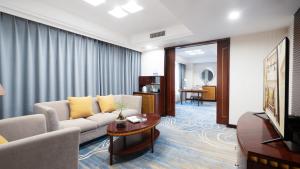 a living room with a couch and a tv at Shunde Grand View Hotel in Shunde