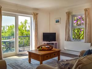 a living room with a television and a table at Seaview Cottage - Uk44707 in Amroth