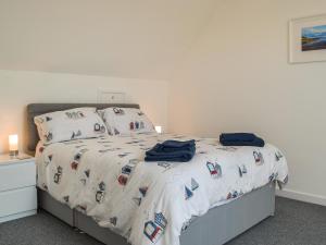 a bedroom with a bed with a comforter and pillows at Seaview Cottage - Uk44707 in Amroth +6 photos