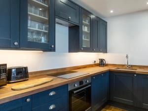 a kitchen with blue cabinets and a wooden counter top at Anchorage View in Dartmouth