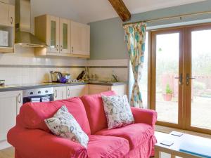 a living room with a pink couch in a kitchen at Shepherdskirk in Kyloe