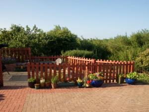 a wooden fence with potted plants on a patio at Shepherdskirk in Kyloe +2 photos