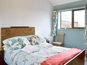 a bedroom with a bed with a blanket on it at Shepherdskirk in Kyloe