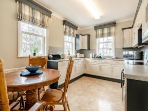 a kitchen with a wooden table and a table and chairs at Wold House Cottage in Nafferton