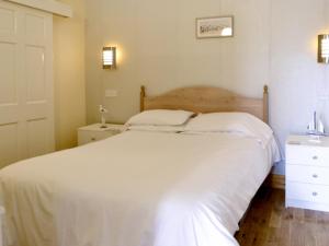 a bedroom with a white bed and a white dresser at Dorn Rock View - Uk33918 in Portpatrick