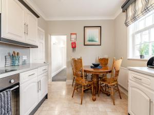 a kitchen with a table and chairs in a kitchen at Wold House Cottage in Nafferton