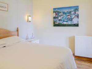 a bedroom with a white bed and a picture on the wall at Dorn Rock View - Uk33918 in Portpatrick