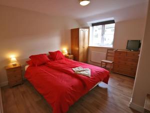 a bedroom with a red bed and a television at New Bakery in Glanton