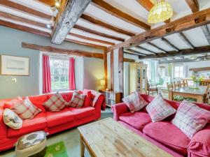 a living room with two red couches and a table at Thwaite Bridge Houseconiston in Coniston