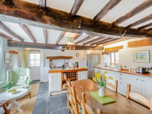 a kitchen and dining room with a table and chairs at Thwaite Bridge Houseconiston in Coniston