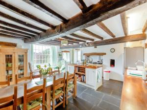a kitchen with wooden ceilings and a table and chairs at Thwaite Bridge Houseconiston in Coniston +43 photos