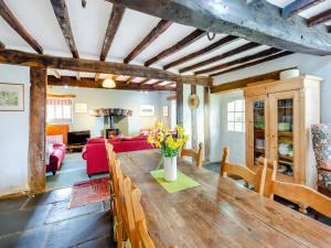 a living room with a wooden table and a red couch at Thwaite Bridge Houseconiston in Coniston