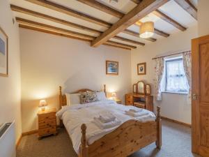 a bedroom with a wooden bed and a window at The Granary - Uk44490 in Sedgefield