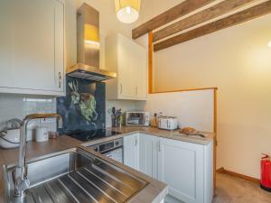 a kitchen with white cabinets and a sink at The Granary - Uk44490 in Sedgefield