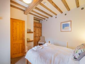 a bedroom with a white bed with a wooden ceiling at The Granary - Uk44490 in Sedgefield +7 photos