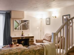 a living room with a chair and a fireplace at Cowshed - Uk49024 in Liskeard