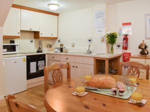 a kitchen with a table with a loaf of bread on it at Cowshed - Uk49024 in Liskeard +5 photos