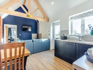 a kitchen and living room with a blue wall at The Cowshed - Uk37349 in Hockerton