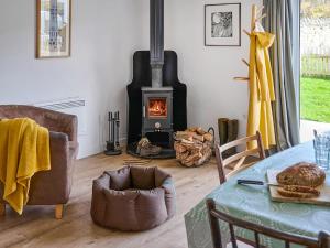 a living room with a fireplace and a table at Bueno - Ukc4682 in Clynnog-fawr