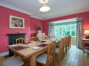 a dining room with a large wooden table and chairs at The Vicarage in Lowick Green