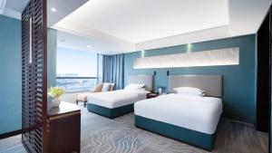 a hotel room with two beds and a couch at Shunde Grand View Hotel in Shunde +23 photos