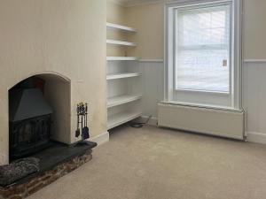 a living room with a fireplace and a window at The Farmhouse - Uk49068 in Liskeard