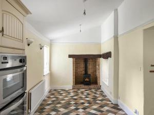 a living room with a fireplace and a checkered floor at The Farmhouse - Uk49068 in Liskeard