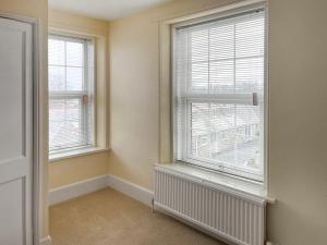 an empty room with two windows and a radiator at The Farmhouse - Uk49068 in Liskeard