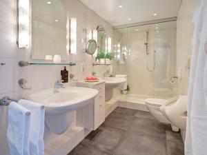 a white bathroom with two sinks and a shower at Das Penthouse mit 3 Dachterrassen, Whirlpool & Panoramablick in Karlsruhe +36 photos