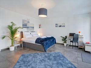 a bedroom with a bed and a desk with a computer at Das Penthouse mit 3 Dachterrassen, Whirlpool & Panoramablick in Karlsruhe