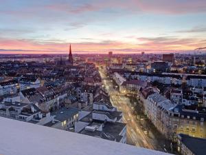 a view of a city at sunset from the top of a building at Das Penthouse mit 3 Dachterrassen, Whirlpool & Panoramablick in Karlsruhe