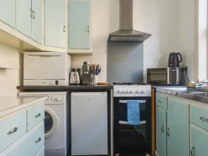 a kitchen with a stove and a dishwasher at Limestone Cottage in Hebden Bridge