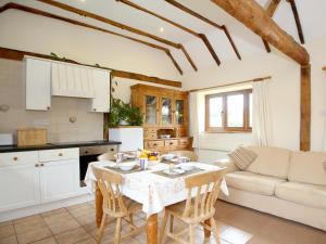 a kitchen and living room with a table and chairs at The Dairy At Copper Beeches in Petersfield