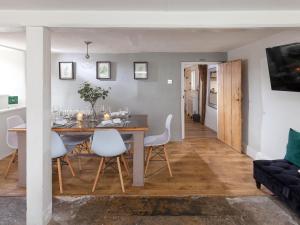 a dining room and living room with a table and chairs at Hurst Cottage in Sturminster Newton