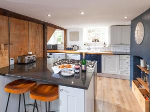 a kitchen with a counter with a sink and a stove at Hurst Cottage in Sturminster Newton