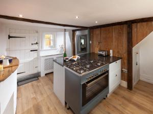 a kitchen with a stove and a counter top at Hurst Cottage in Sturminster Newton