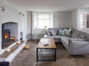a living room with a couch and a fireplace at Hurst Cottage in Sturminster Newton