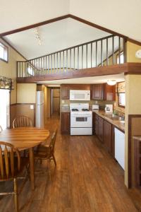 a kitchen with a wooden table and a dining room at Arrowhead Camping Resort Cottage 11 in Douglas Center +10 photos