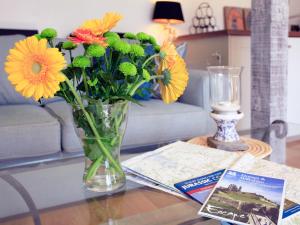 eine Vase mit Blumen auf einem Tisch im Wohnzimmer in der Unterkunft Alpaca Cottage in Frampton