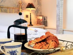 Ein Teller mit Gebäck auf einem Tisch mit einer Kaffeemaschine. in der Unterkunft Alpaca Cottage in Frampton