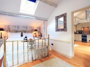 ein Schlafzimmer mit einem Bett mit Spiegel und eine Küche in der Unterkunft Alpaca Cottage in Frampton