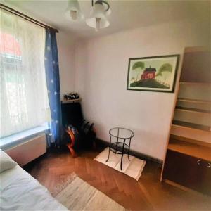a room with a bed and a table next to a window at Let's go back to the memories in Krakow