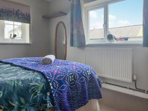 a bedroom with a bed and a mirror and windows at Heron's Lodge in Llanarthney +11 photos