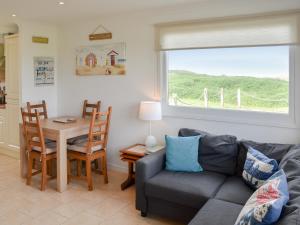 a living room with a couch and a table and a window at On The Beach in Bacton
