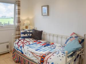 a bedroom with a bed and a window at On The Beach in Bacton