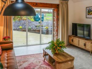 a living room with a couch and a tv at Stables in Carmarthen