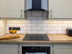 a kitchen counter with a stove and a bowl of fruit at Stables in Carmarthen
