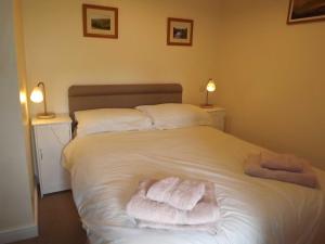 a bedroom with a white bed with towels on it at Skellgill House in Askrigg