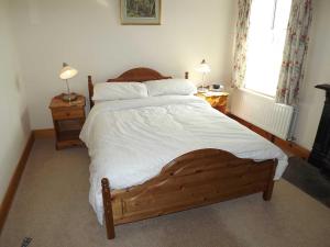 a bedroom with a large bed with white sheets and pillows at Skellgill House in Askrigg